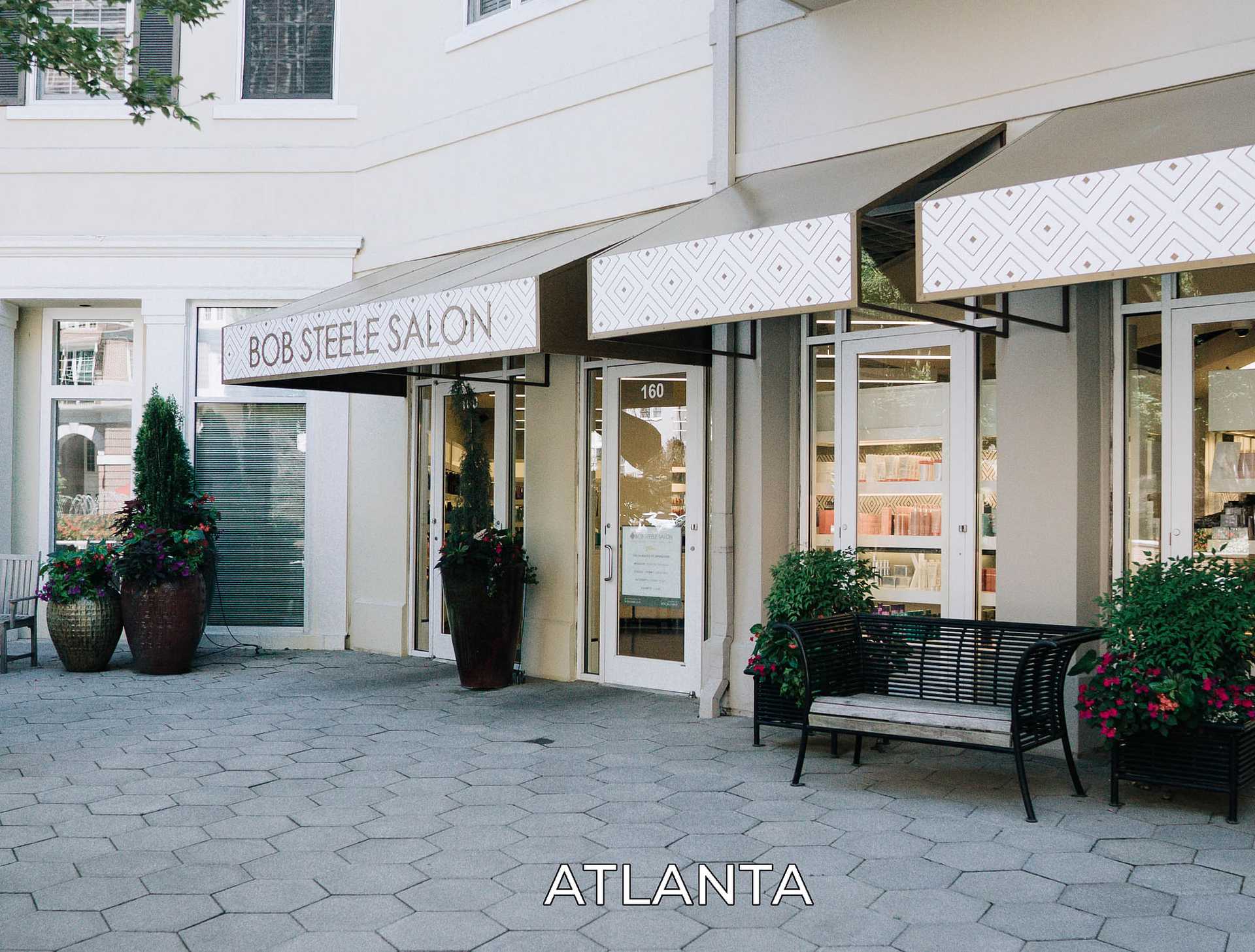 Exterior view of Bob Steele Salon with plants and bench in front, located in Atlanta.