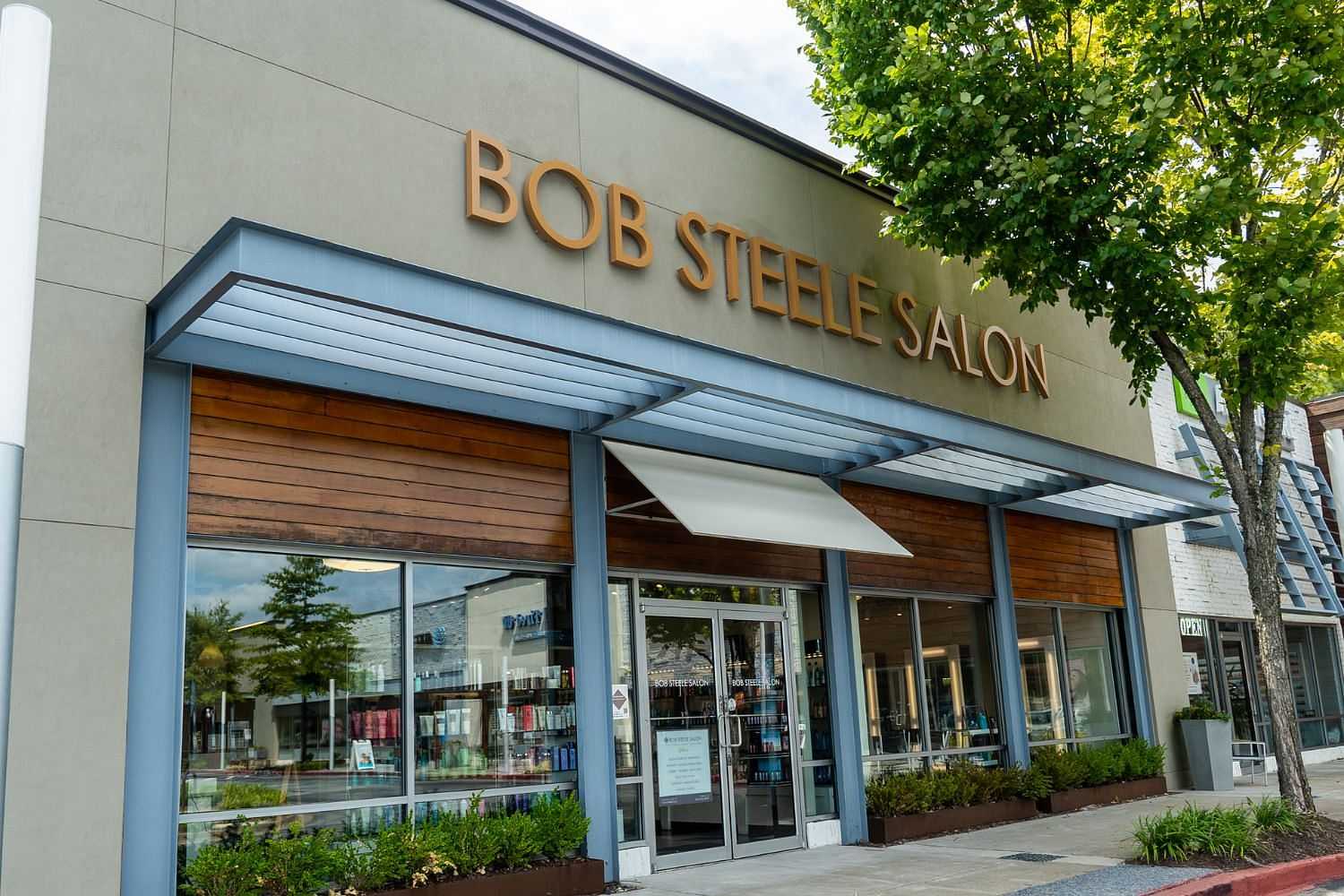 Front view of Bob Steele Salon with large windows and modern design, surrounded by trees.